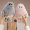 Two soft plush monster dolls in gray and pink are being held by hands.