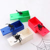 A set of three colorful trick boxes, including blue, green, and red, each containing a black spider for a prank or gag gift.