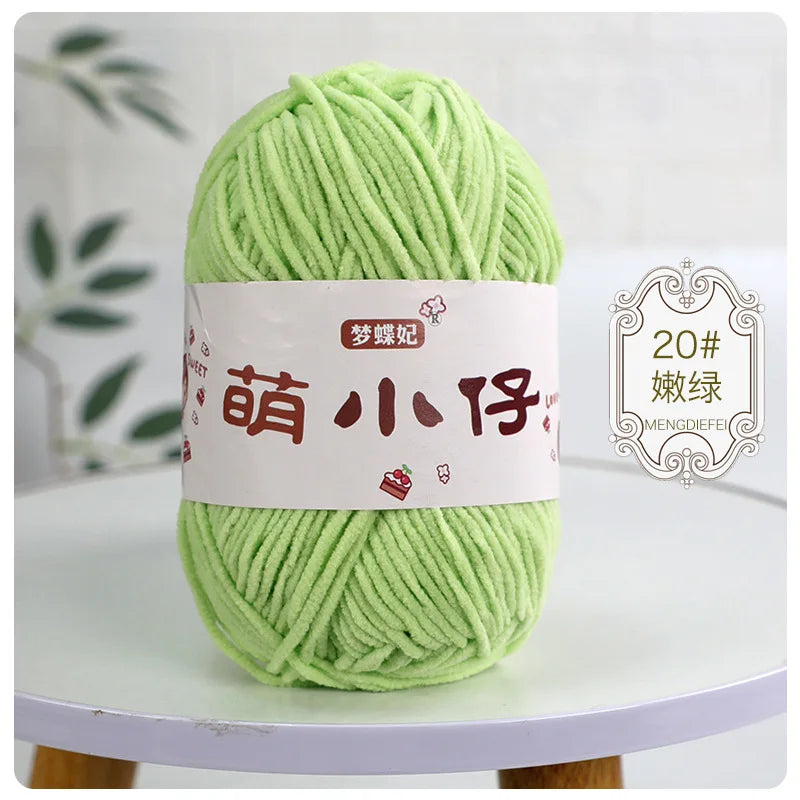 A ball of light green chenille yarn with Chinese characters on the label, displayed on a white table.
