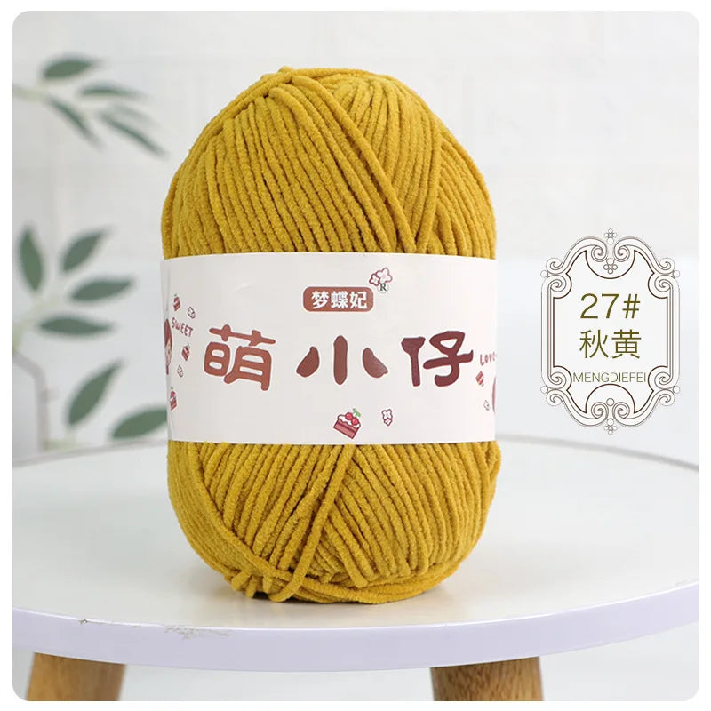 A ball of golden yellow chenille yarn labeled with Chinese characters for knitting and crochet.