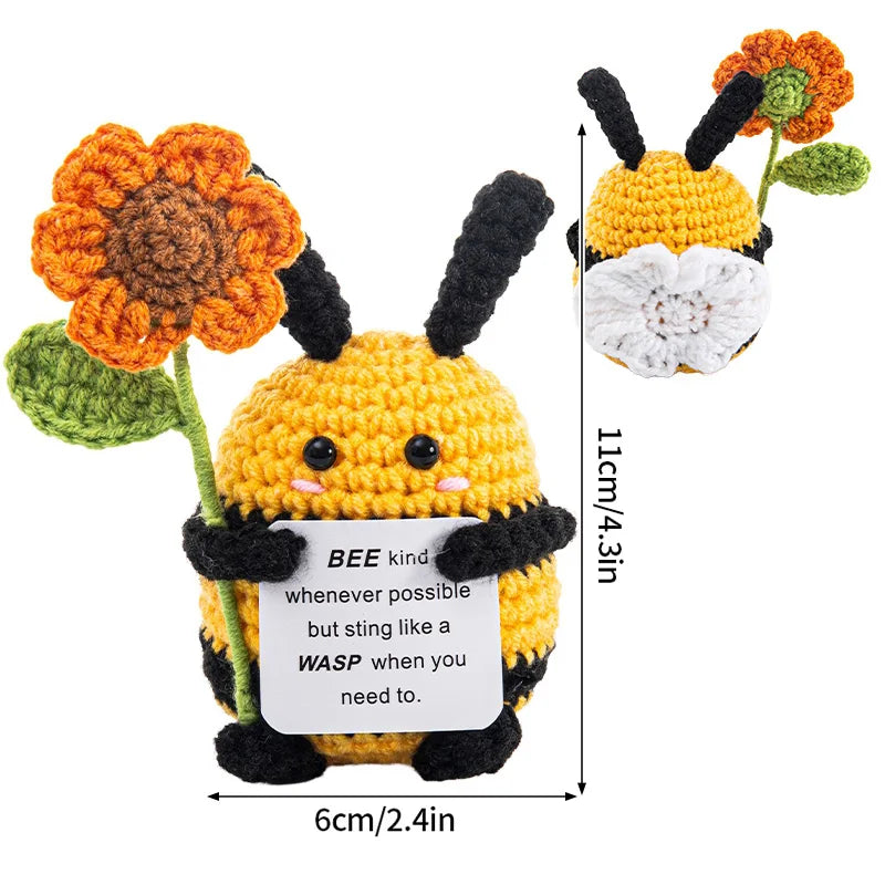 Handmade crochet bee doll with orange and yellow body and black stripes, featuring an inspirational slogan.