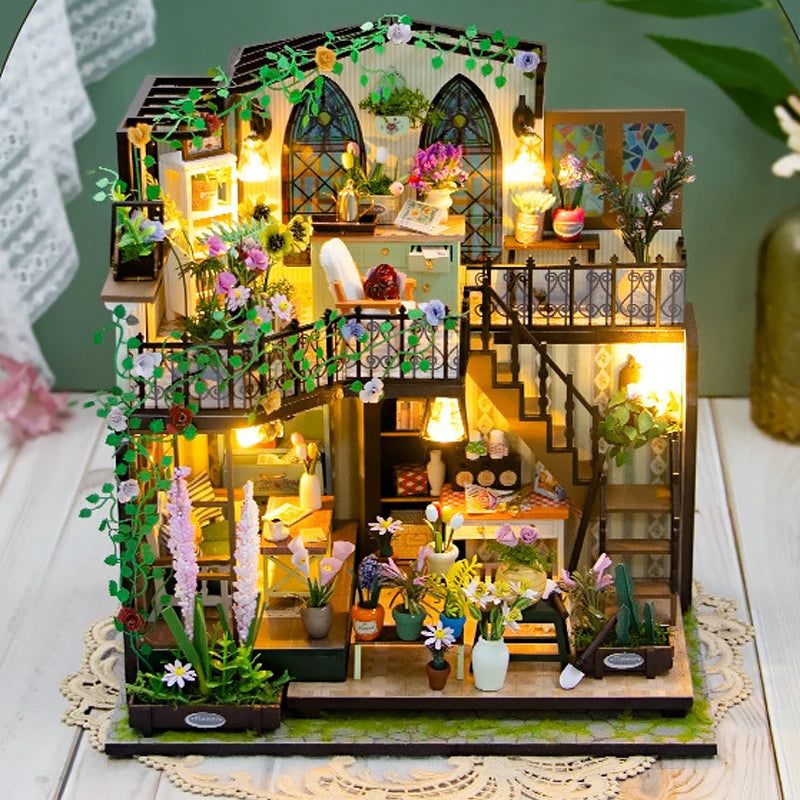 A detailed DIY miniature dollhouse kit featuring furniture, greenery, and warm lighting.