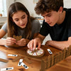 Two people play a magnetic hangman board game on a wooden table with pieces and a wooden frame.