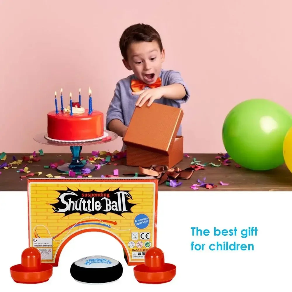 A boy is looking at a box of Mini Floating Air Hockey Set with 2 Pushers, which is the best gift for children.