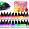 A collection of 20 liquid colorants in glass bottles for soap and candle making, displayed next to a yellow candle and an ora