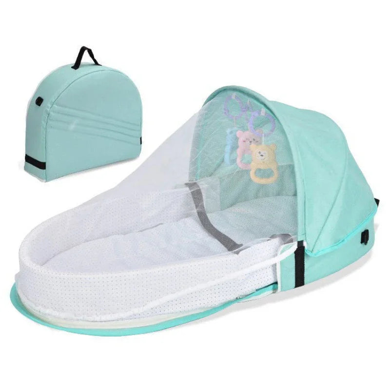 A light mint green portable foldable baby bed with a mosquito net and mattress.