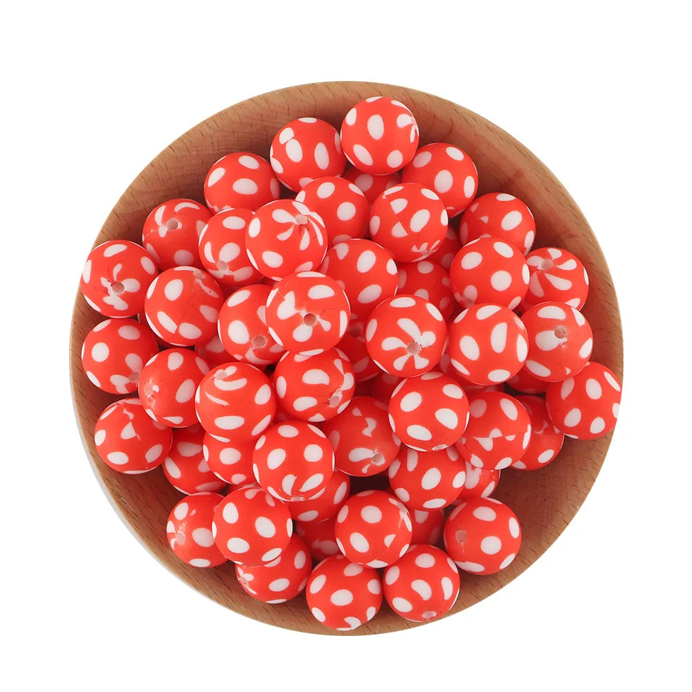 A pile of bright red silicone beads with white polka dots in a wooden bowl.