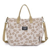 A beige floral canvas tote bag with multiple pockets and tan handles.