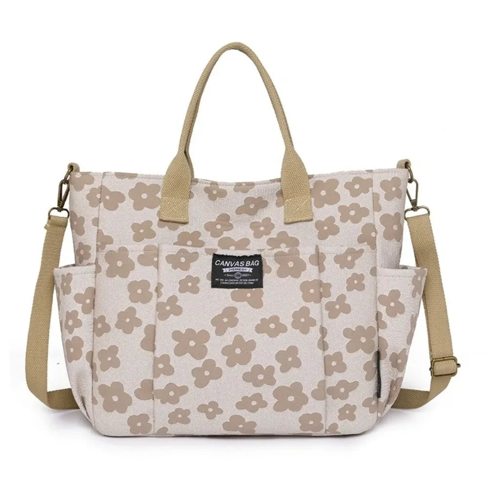 A beige floral canvas tote bag with multiple pockets and tan handles.