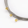 A close-up view of light gauge electric guitar strings in silver and gold colors coiled together.