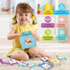 A young girl is holding a blue talking flash card learning machine with various educational features.