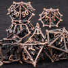 A set of metallic, spiky dice in bronze and black are arranged on a dark surface.