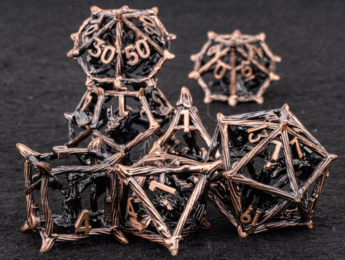 A set of metallic, spiky dice in bronze and black are arranged on a dark surface.