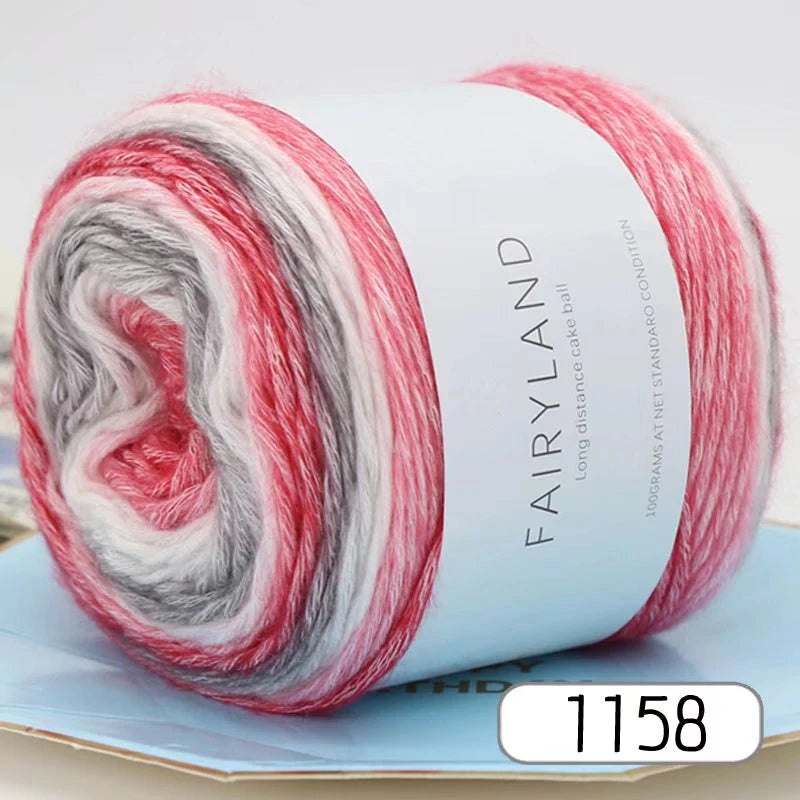 Roll of gradient rainbow yarn with red, white, and gray stripes for knitting and crochet
