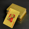 A single gold-colored poker playing card featuring a stylized joker design, resting on top of a stack of similar cards.