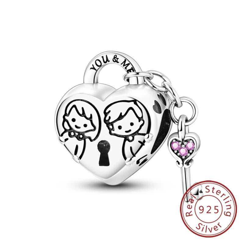 A sterling silver heart charm engraved with the words You & Me and two figures.