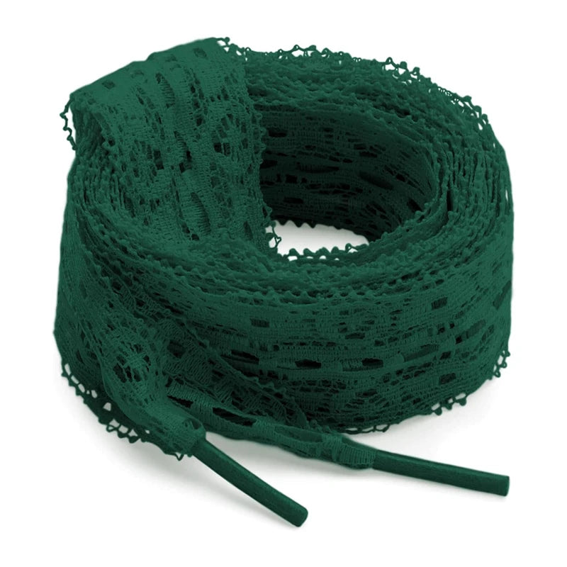 A spool of dark green flat elastic silk lace shoelaces coiled on a white background.