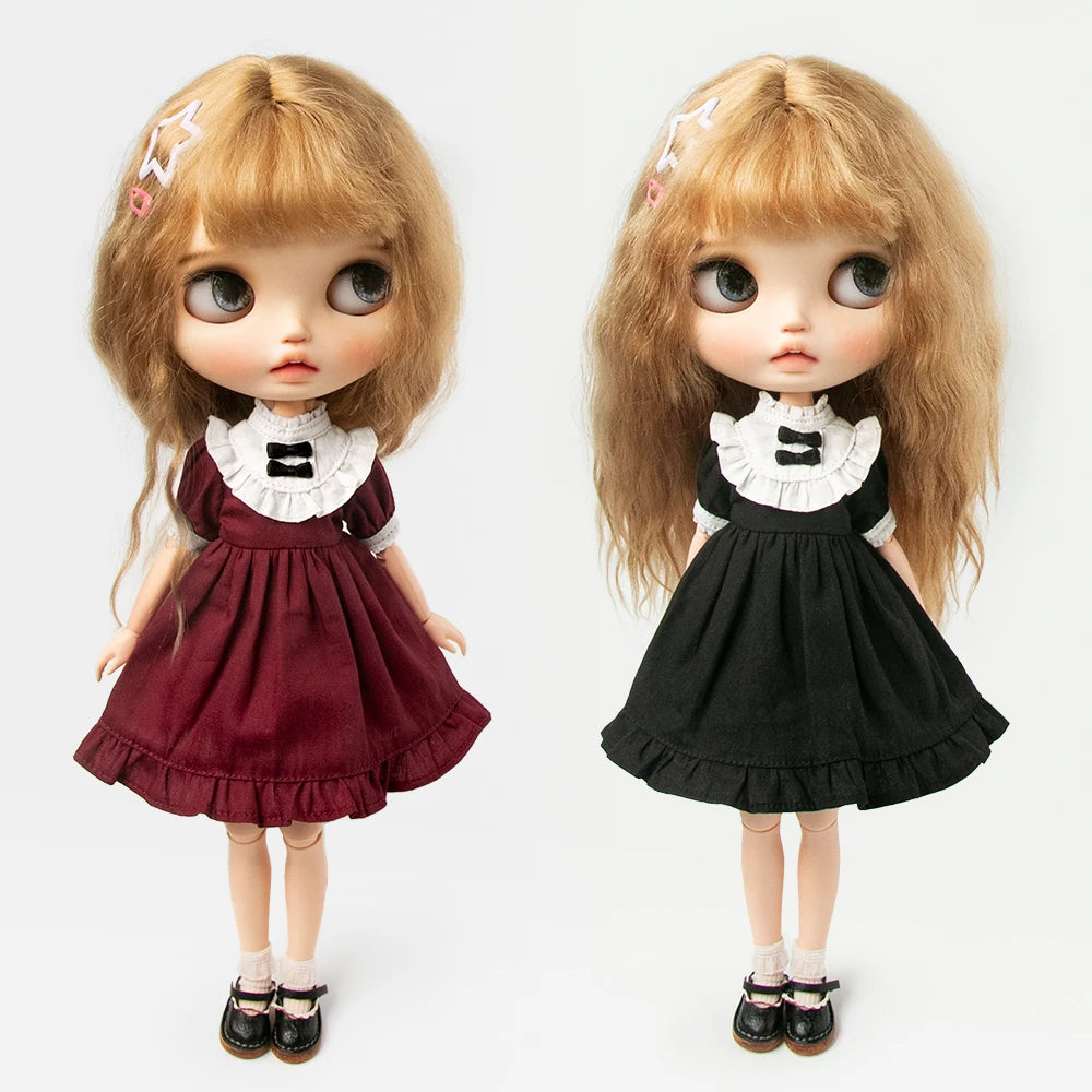 A pair of vintage lace maid dress sets for 1/6 scale dolls, featuring a maroon and black dress with white lace collar.