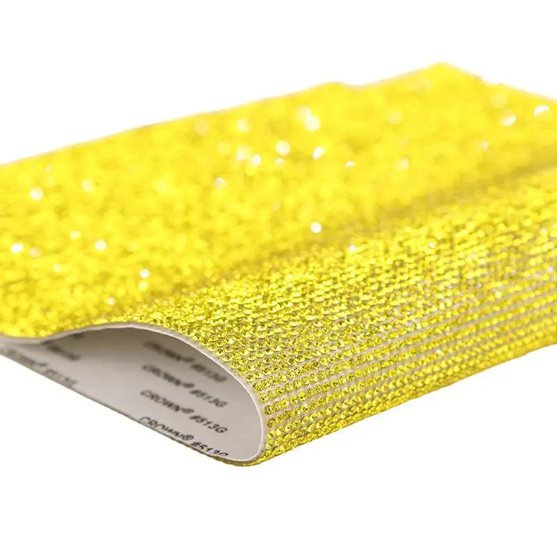 Yellow sparkling rhinestone adhesive tape rolled up for DIY crafts and decor