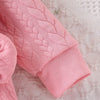 Pink quilted baby girl romper with a lace collar shown in a close-up view.