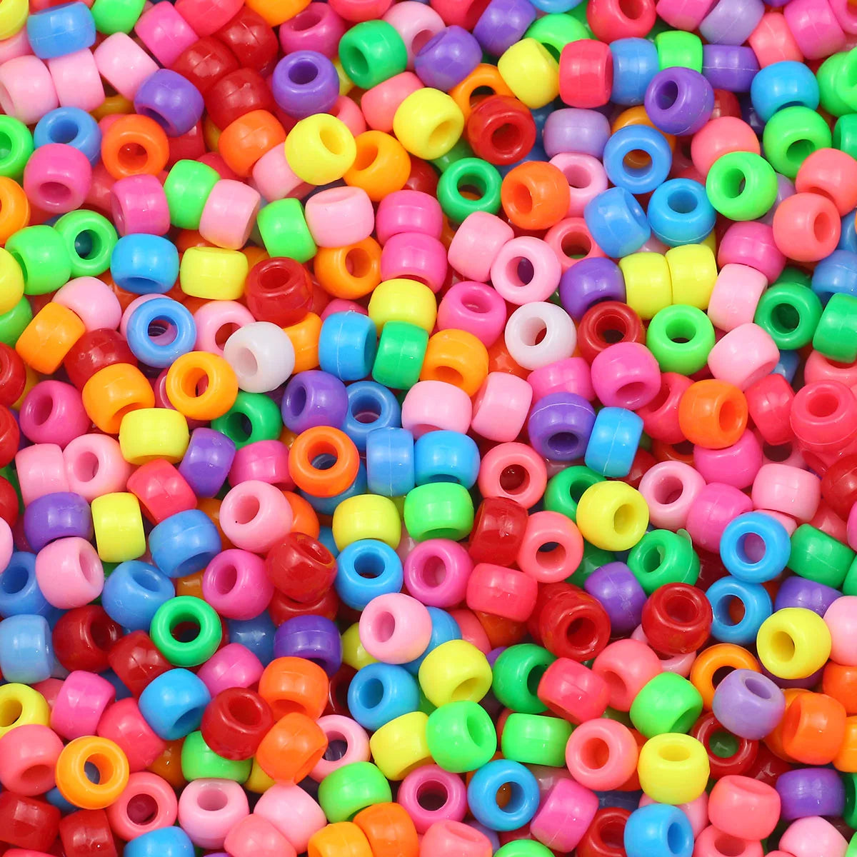 A close-up view of a large pile of solid color pony beads in various shades including pink, green, yellow, blue, and orange.