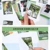 A hand is holding several green and black nature-themed stickers for a seasonal scenery variety pack.