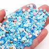 A hand holds a pile of blue and white polymer clay slices for DIY crafts