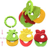 A set of silicone baby teethers in green, red, and yellow shapes for soothing gums.