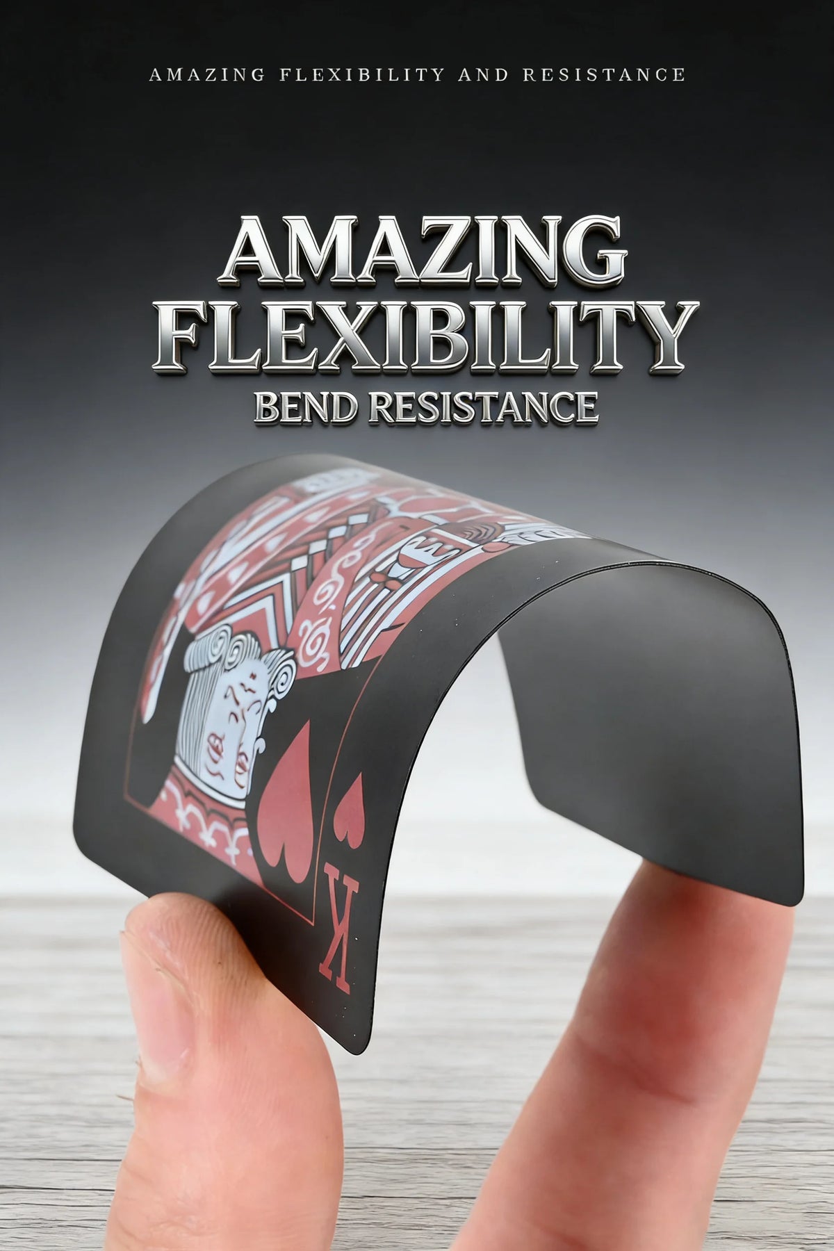 A hand holds a black plastic playing card deck demonstrating amazing flexibility and bend resistance.