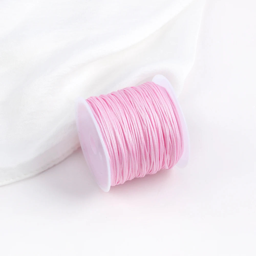 A pink roll of 0.8mm cotton nylon macrame cord for jewelry making and crafts.