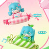A blind box figure of Hatsune Miku with a pink and green striped candy theme.