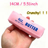 A hand holds a pink butter stress ball labeled 40 oz salted butter with a crunchy texture.