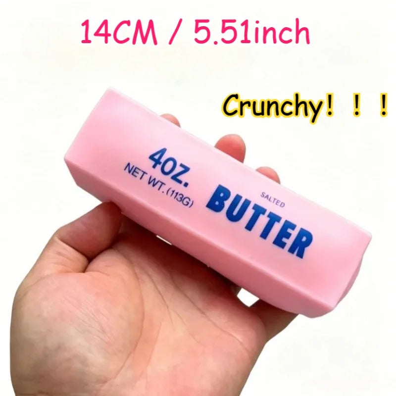 A hand holds a pink butter stress ball labeled 40 oz salted butter with a crunchy texture.