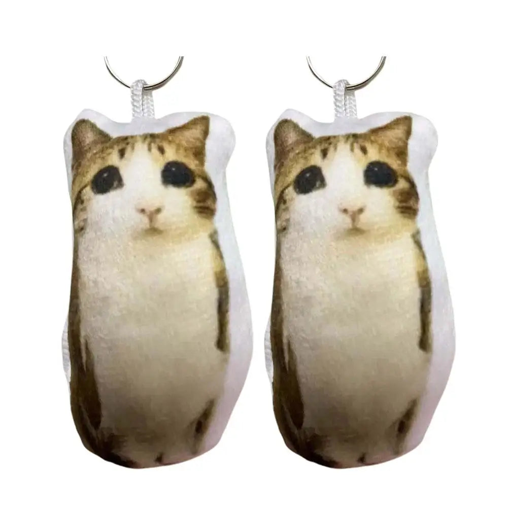 A pair of realistic cat plush keychains with dangling silver loops.