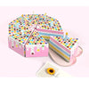 A stack of colorful paper gift boxes shaped like candles with dot patterns and dripping icing on a pink background.