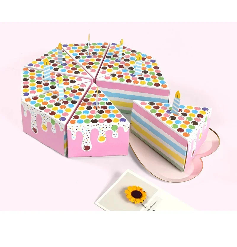 A stack of colorful paper gift boxes shaped like candles with dot patterns and dripping icing on a pink background.