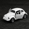A white 1:38 die-cast model of a classic Beetle car shown from the side.