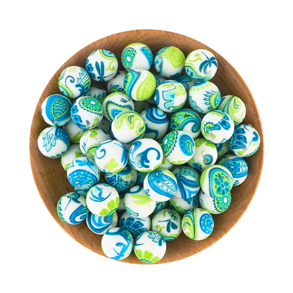 A wooden bowl filled with colorful silicone beads for jewelry making in various shades of blue and green.