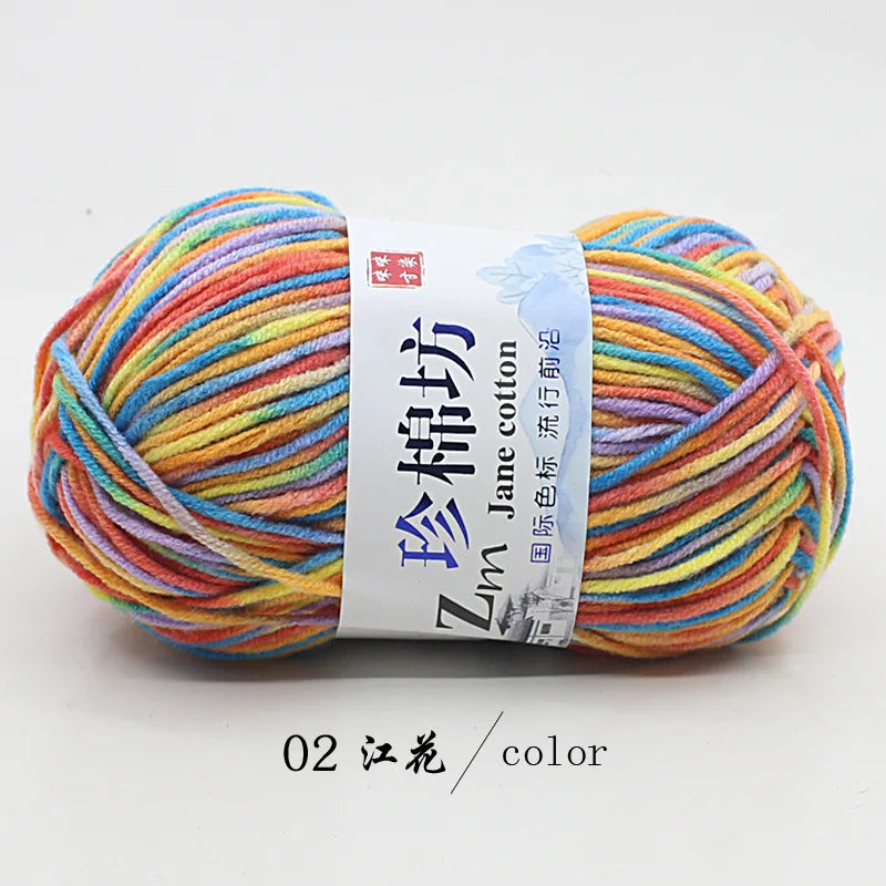 A ball of multi-colored yarn, featuring shades of orange, yellow, blue, and pink, labeled as Zun Jane cotton yarn.