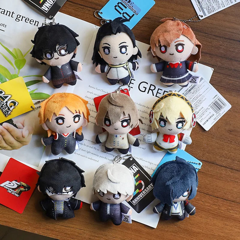A collection of anime character plushie pendants and charms displayed on a wooden surface.