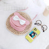Pink kids hard shell crossbody bag with mouse ears and a white bow resting on a woven mat.