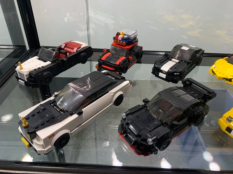 A collection of classic supercar building blocks, including a black and white sports car and a red and black race car.