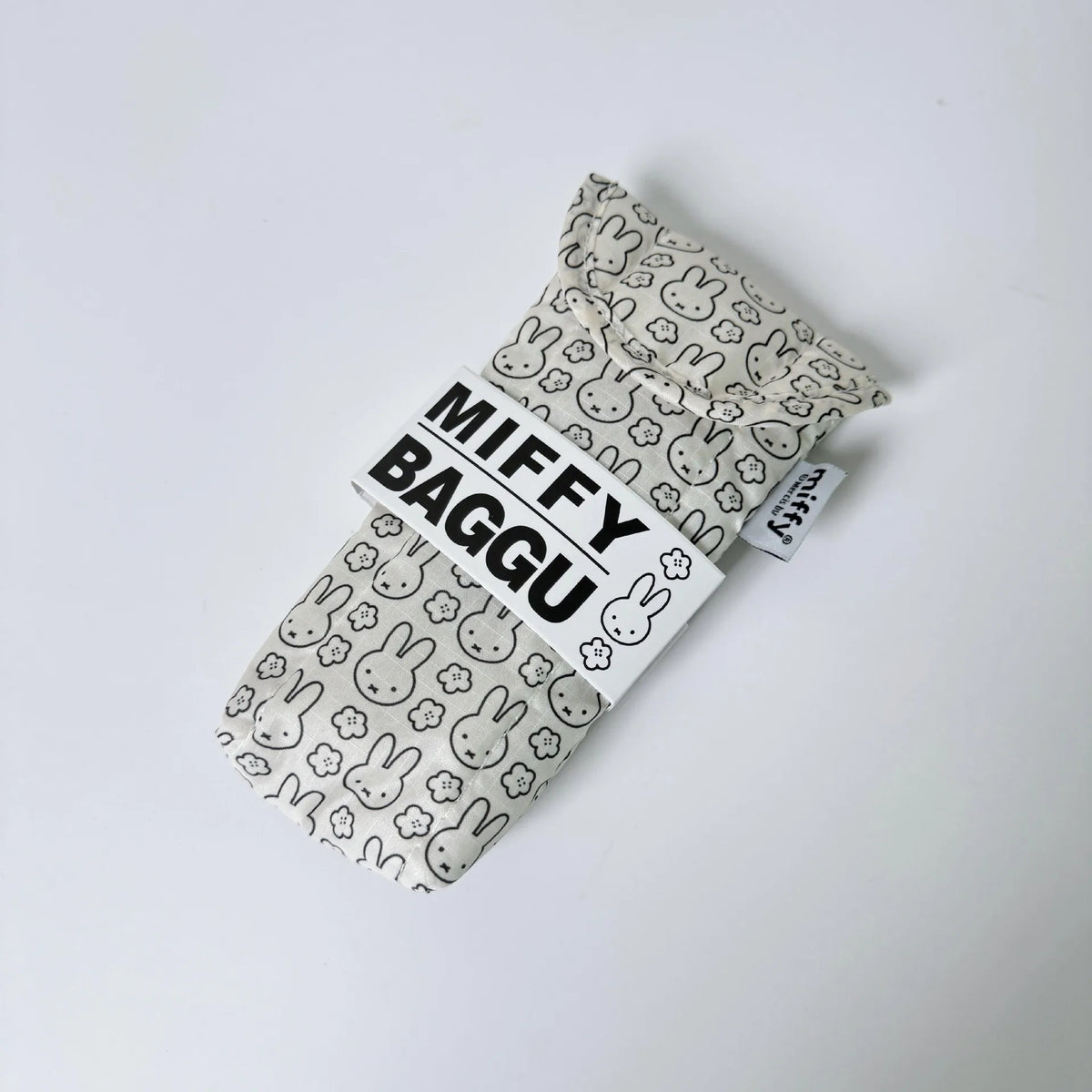 A white soft cotton storage bag with a repeating pattern of Miffy rabbits, used as a magnetic glasses case.