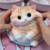 A fluffy orange and white cat shaped squishy stress relief toy is being held by a person.