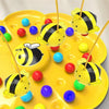 A yellow board game featuring a bee theme with colorful balls and fishing rods for kids
