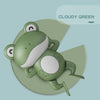 A light green wind-up frog bath toy for kids is shown resting on a pale green background.