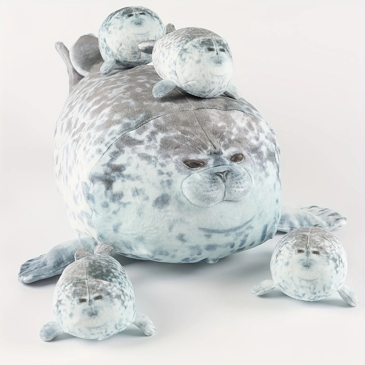 A plush seal family pillow featuring a large adult seal and four smaller baby seals.
