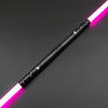 A black lightsaber staff with a glowing pink blade is shown diagonally on a dark surface.