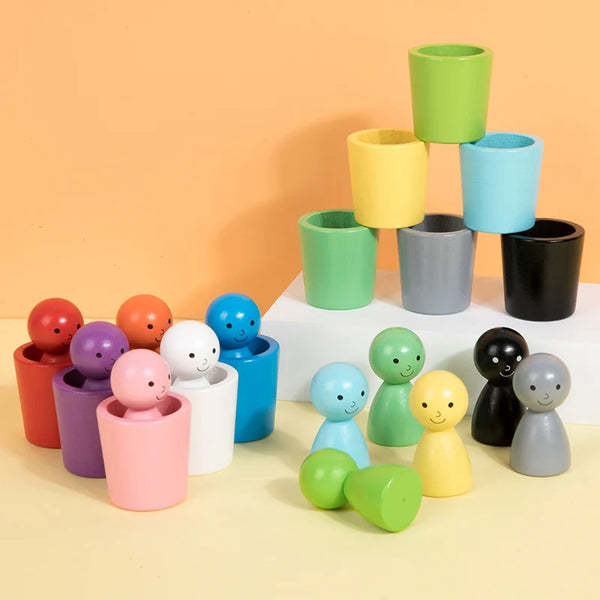A collection of wooden color sorting toys in various shades of green, yellow, blue, and gray stacked on a white surface.