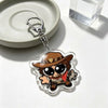 An acrylic keychain charm featuring an anime-inspired character wearing a brown hat and bandana.